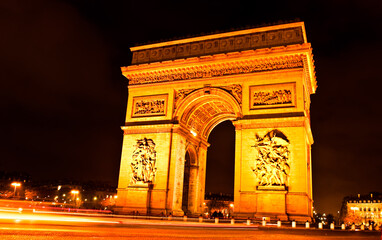 Fototapeta na wymiar Arc de Triomphe in Paris illuminated with lights in the night...
