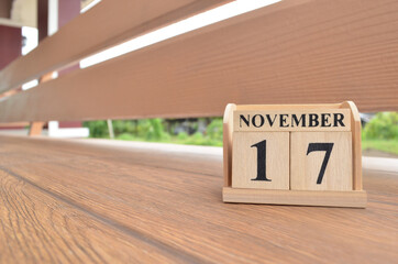 November 17, Number cube with wooden balcony background.