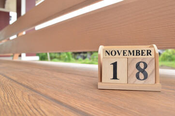 November 18, Number cube with wooden balcony background.