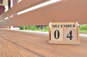 December 4, Number cube with wooden balcony background.