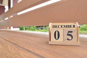 December 5, Number cube with wooden balcony background.