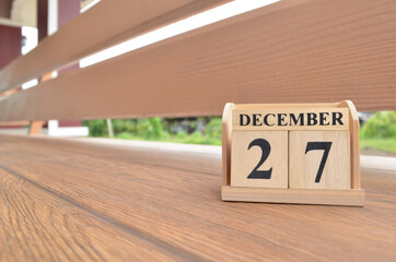 December 27, Number cube with wooden balcony background.