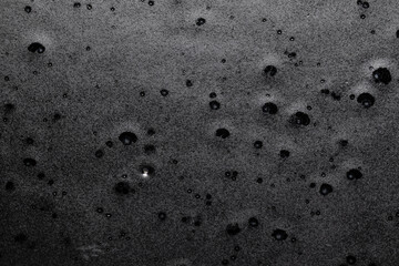 Craters in dark rock pitted