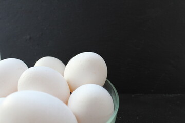 food preparation of Breakfast eggs white chicken lie in a glass bowl plate on a gray black...