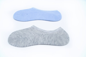 Two pairs of new short socks of blue and gray color are lying on a white background. New socks pulled on a cardboard.