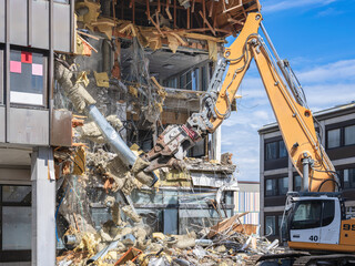 Demolition excavator tearing down a building in Kuopio, Finland