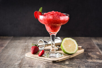 Strawberry margarita cocktail in glass on wooden table
