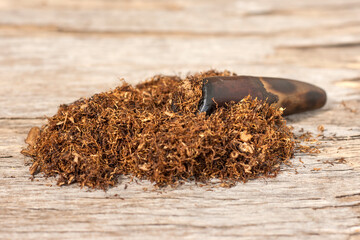 Tobacco and smoking pipe on a wooden background