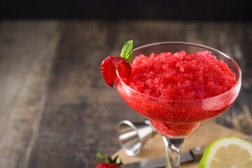 Strawberry margarita cocktail in glass on wooden table.Copy space
