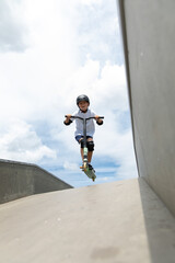 The boy jumps on a scooter.