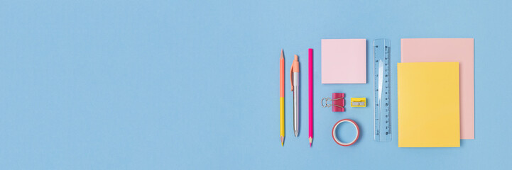 Banner with colorful school supplies on a blue pastel background. Stationery creative concept with...