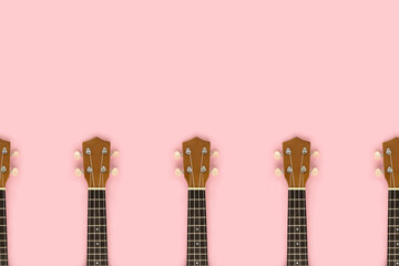 Frame made of guitar fretboards on a pink pastel background. Musical event invitation template.
