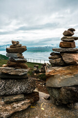 Pile of stones on the hill with view to the Tromso area, northern Norway. Fiord with mountains and sea in the background. Climbing mountain.
