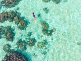 Aerial top down people snorkeling on coral reef tropical caribbean sea, turquoise blue water. Indonesia Wakatobi archipelago, marine national park, tourist diving travel destination