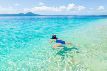 Woman snorkeling in caribbean sea, turquoise blue water, tropical island. Indonesia Banyak Islands...