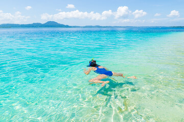 Woman snorkeling in caribbean sea, turquoise blue water, tropical island. Indonesia Banyak Islands Sumatra, tourist diving travel destination.