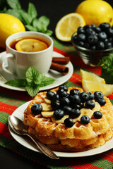 Belgian waffles with blueberry and a cup of tea with lemon	