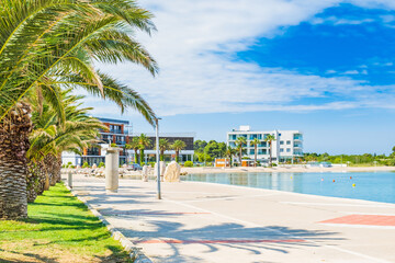 Croatia, beautiful Adriatic coastline, town of Novalja on the island of Pag, city center, marina, walkaway with palms