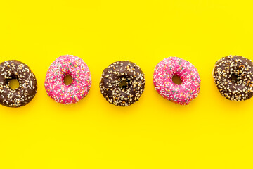 Colorful donuts pattern top view. Strawberry and chocolate donuts
