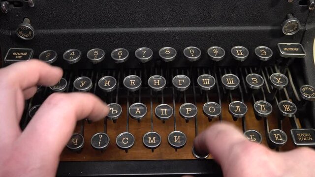 Close up view russian Buttons of old antique typewriter. Man hands press it.