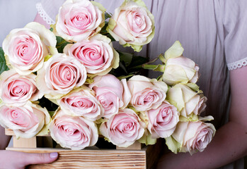 Bouquet of frutteto roses in wooden box in woman hands