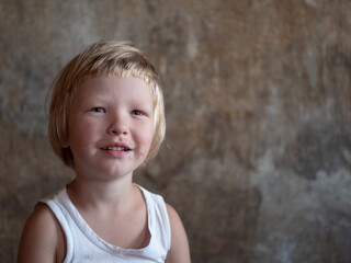 little fair-haired boy is smeared with blood. baby has weak vessels in nose bursting with pressure drops and changes in weather. Hemophilia disease. Blond child lifts his head to stop the bleeding