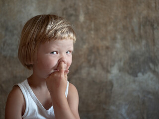 little fair-haired boy is smeared with blood. baby has weak vessels in nose bursting with pressure...