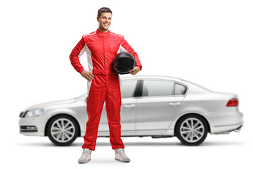 Racer standing and holding a helmet in front of a silver car