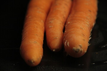 fresh and organic carrots on a black background