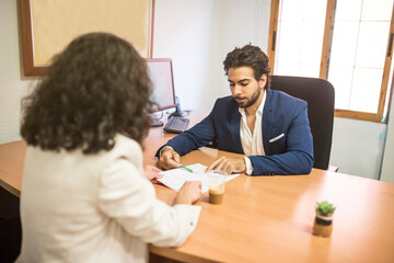 woman in interview with young businessman looking paper