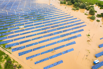 Aerial view of flooded solar power station with dirty river water in rain season.