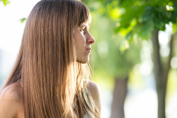 Portrait of pretty young woman standing outdoors in summer.