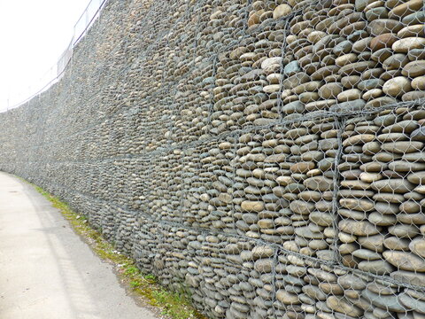 Wall of stones under the grid - gabion