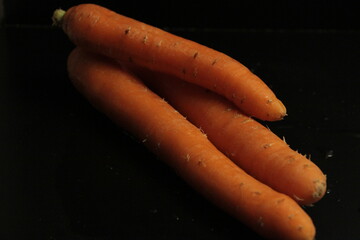fresh and organic carrots on a black background