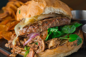 Cheese Burger. Classic American favorite cuisine. Hamburger with jalapenos , grilled mushrooms and melted cheeses and served with hand cut french fries. 