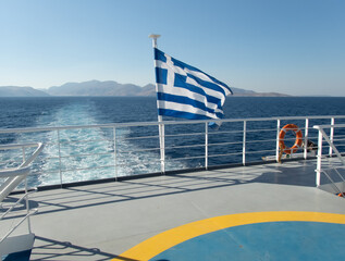 Speed boat traces on water in the Aegean sea. Boat and flag of Greece in motion. Europe