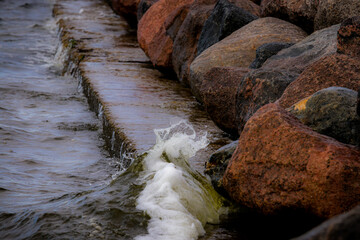 water flowing over rocks,stone fortifications of the seashore, granite stones