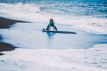 Fototapeta na wymiar A young blonde boy enjoying a funny surf day in the beach in holidays