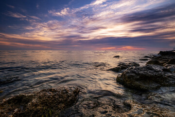 Dramatic sunset over beach with a natural pond in the foreground.
