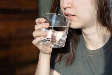 Asian Woman Drinking Water With a Glass