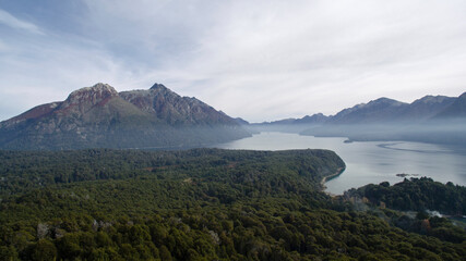 Fototapeta na wymiar Wilderness. Aerial view of lake Nahuel Huapi, the forest foliage, mist and mountains. 