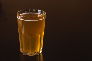 glass of light beer isolated on a dark background