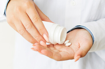 Female doctor showing pills in the hands of a close-up. The appointment of treatment.
