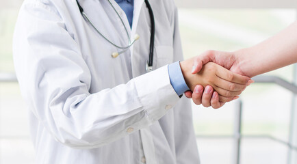Doctor shakes hands with a patient isolated on white background