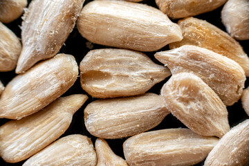 Fullscreen macro closeup with shallow depth of field of sunflower seeds on a black background. Texture. Graphic design.