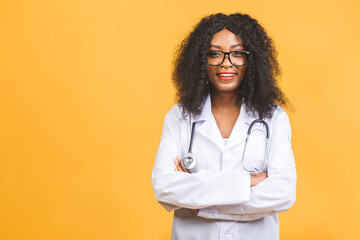 Female African American doctor or nurse smiling isolated over yellow background.