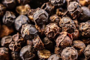 Fullscreen macro closeup with shallow depth of field of unmilled black peppercorns