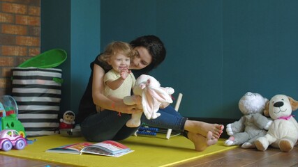 Fototapeta premium Mother and daughter playing with Stuffed Bunny