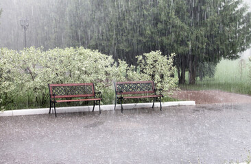 Rain and hail on a summer day. Large puddles on the sidewalk during heavy rain. Heavy rain with...