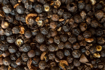 Fullscreen macro closeup with shallow depth of field of unmilled black peppercorns